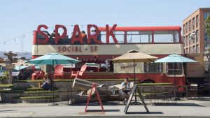 Visitors to Spark Social SF lounging in the park