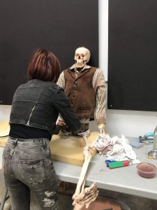 A lady dressing a skeleton